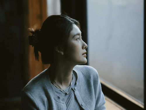 Mulher olhando para a janela refletindo Mulher olhando para a janela refletindo