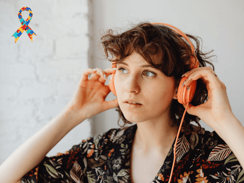Mulher ajustando fones de ouvido, com símbolo do autismo em destaque. Mulher ajustando fones de ouvido, com símbolo do autismo em destaque.